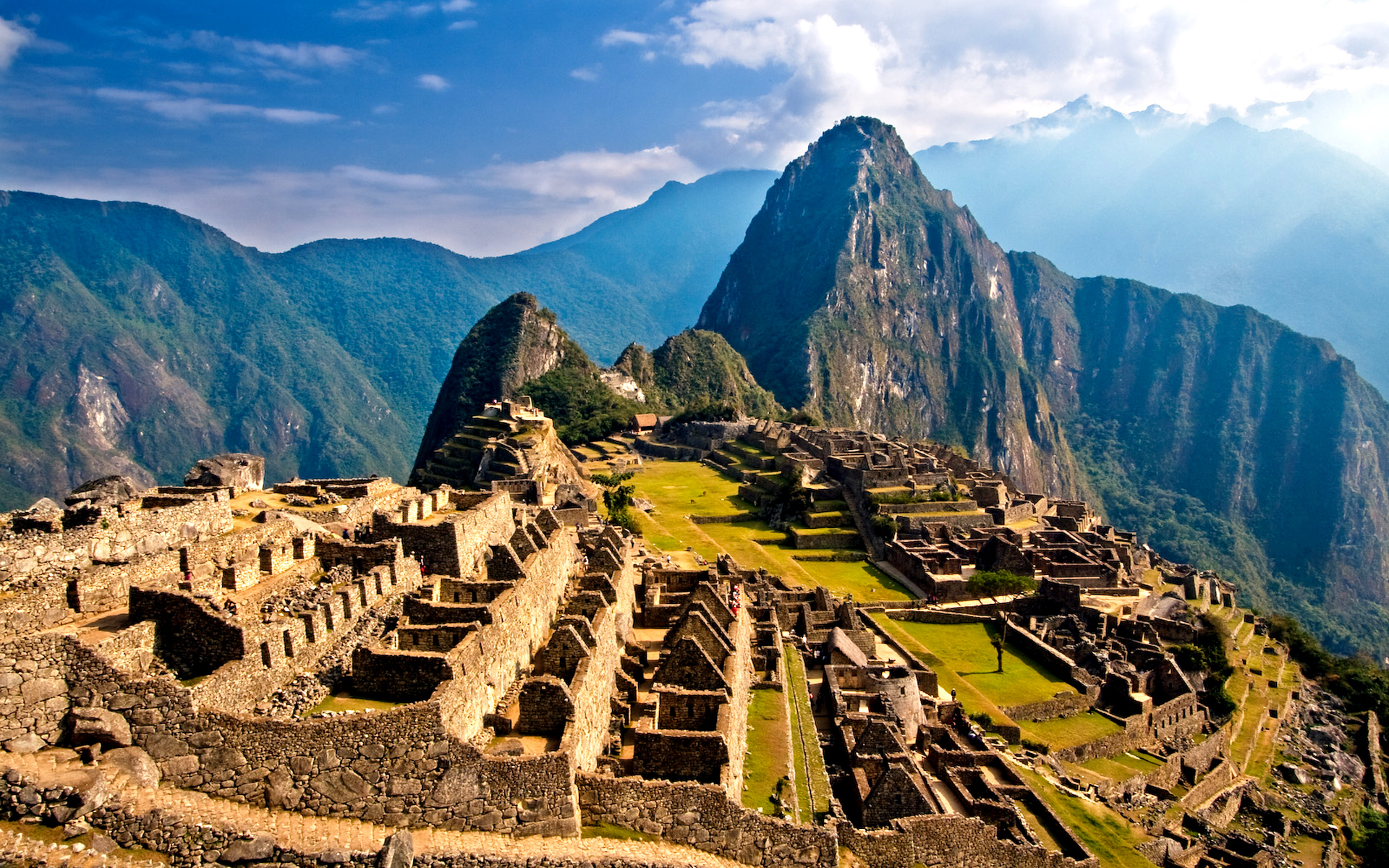 The stone terraces and buildings of Machu Picchu among high green mountains in Peru